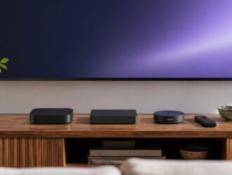 Three generic streaming boxes and a remote below a television.